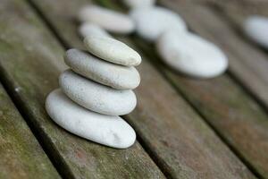 Gray river pebbles on an old wooden surface. Closeup photo