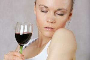 Young lady keeps a glass of red wine in her hand photo