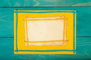 Yellow felt fabric on a wooden surface.Top view photo