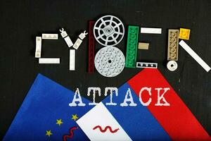 Cyber-attack is composed of plastic mini block on a black surface. Background photo