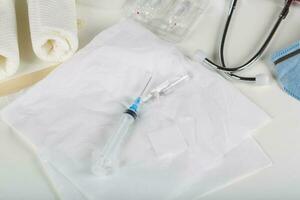 Syringe, alcohol wipe and glass ampule with antibiotics on a white napkin.Top view photo