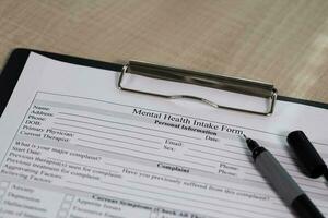 Mental health intake form and a pen on a table. photo