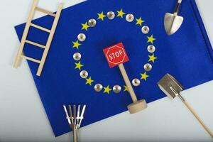 Agricultural tools,a card with access forbidden,pins,and a passport on an European flag.Closeup photo