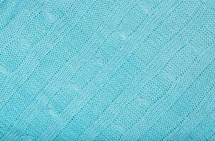 Blue coloured knitted surface. Closeup photo