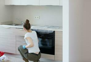 Young lady stays in front newly installed kitchen photo