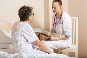 Geriatrician visits a senior woman photo