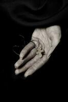 de madera hecho a mano cruzar en el palma de un campesino mujer. foto