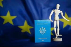 Moldovan pass and wooden dummy figurine on the European flag. photo