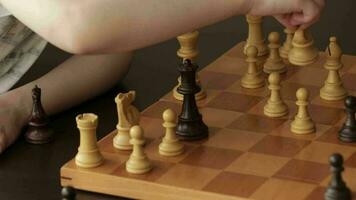 Father and a son are playing chess. Closeup video
