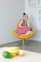 Young lady in the yellow armchair photo