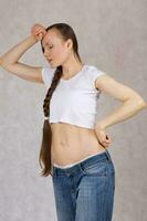 Young lady dressed in jeans lost her overweight. Closeup photo