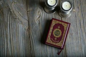 Quran and candles on a wooden surface. photo