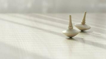 Two small spinning top moving on a table with negative space. video