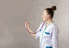 Young female doctor dressed in a white medical uniform photo