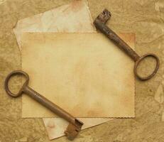 Two old rusted keys on an old surface. photo