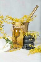 Mimosa flowers massage oil  in glass bottle. photo