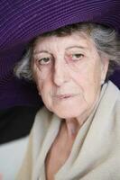 Old caucasian woman in a violet hat photo