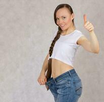 Young lady dressed in jeans lost her overweight. Closeup photo