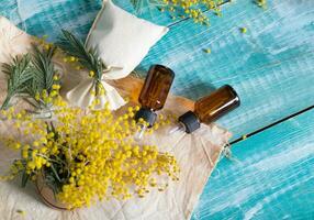 Mimosa essential oil on a wooden surface. photo