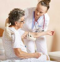 Geriatrician helps a senior woman  to stand up photo