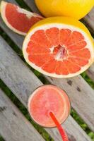 Pieces of grapefruit and a glass of fresh squeezed grapefruit juice.Top view photo