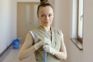 Young cleaning lady is cleaning the corridor. photo