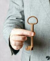 An old key in the hand of a man. photo