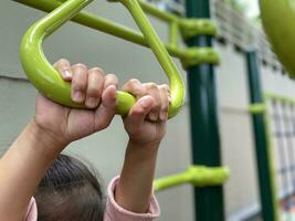 hands of girl hanging at playground. photo