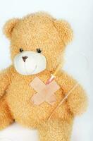 Teddy bear with blood transfusion system. Closeup photo