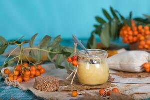 Rowan berries, glass with honey and honeycomb on a sackcloth. . photo