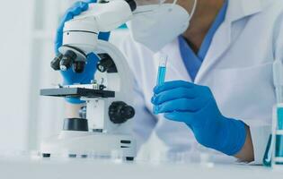 hand of scientist with test tube and flask in medical chemistry lab blue banner background photo