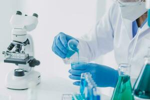 hand of scientist with test tube and flask in medical chemistry lab blue banner background photo