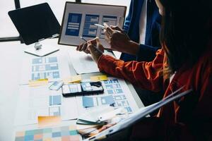 Close up ux developer and ui designer brainstorming about mobile app interface wireframe design on table with customer breif and color code at modern office.Creative digital development agency photo