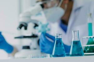 hand of scientist with test tube and flask in medical chemistry lab blue banner background photo