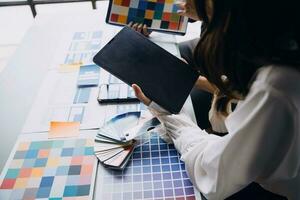 Close up ux developer and ui designer brainstorming about mobile app interface wireframe design on table with customer breif and color code at modern office.Creative digital development agency photo