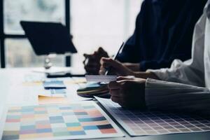 Close up ux developer and ui designer brainstorming about mobile app interface wireframe design on table with customer breif and color code at modern office.Creative digital development agency photo