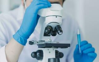 Medical Development Laboratory Caucasian Female Scientist Looking Under Microscope, Analyzes Petri Dish Sample. Specialists Working on Medicine, Biotechnology Research in Advanced Pharma Lab photo