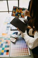 Close up ux developer and ui designer brainstorming about mobile app interface wireframe design on table with customer breif and color code at modern office.Creative digital development agency photo