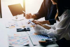 Close up ux developer and ui designer brainstorming about mobile app interface wireframe design on table with customer breif and color code at modern office.Creative digital development agency photo
