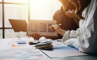 Close up ux developer and ui designer brainstorming about mobile app interface wireframe design on table with customer breif and color code at modern office.Creative digital development agency photo