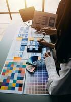 Close up ux developer and ui designer brainstorming about mobile app interface wireframe design on table with customer breif and color code at modern office.Creative digital development agency photo