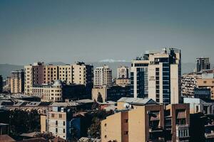 Cityscape in a morning time view in full color concept photo. Beautiful urban scenery with far mountains peak photo