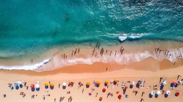 people on the beach and sea waves top view taking by drone summer vibes on crowed beach photo