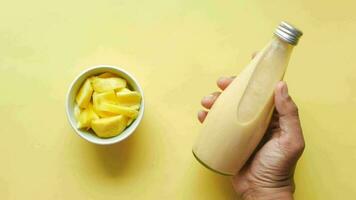 Mango-Smoothie und frische Mango auf gelbem Hintergrund video