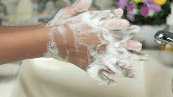 Slow motion of young man washing hands with soap warm water video