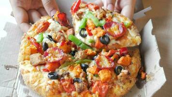 Top view of man hand picking slice of pizza from a plate video