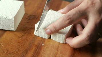 Top view of hands cutting Tofu with knife video