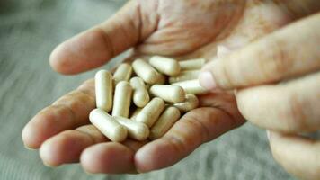 Top view of herbal medicine capsule on hand on white background video