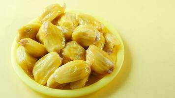 Top view of slice of jackfruits in plate on yellow background video