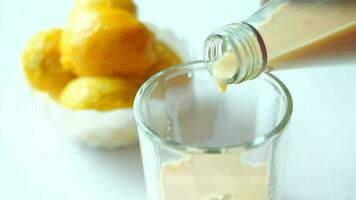 pouring mango smoothie and fresh mango on white background video